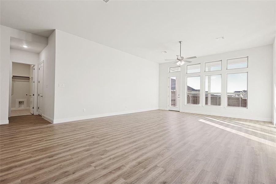 Unfurnished living room with ceiling fan and light hardwood / wood-style floors