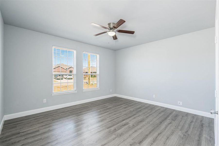 Spare room featuring a ceiling fan, baseboards, and wood finished floors