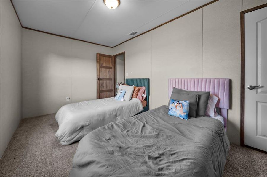 Bedroom with carpet floors and ornamental molding Bedroom with carpet floors and ornamental molding