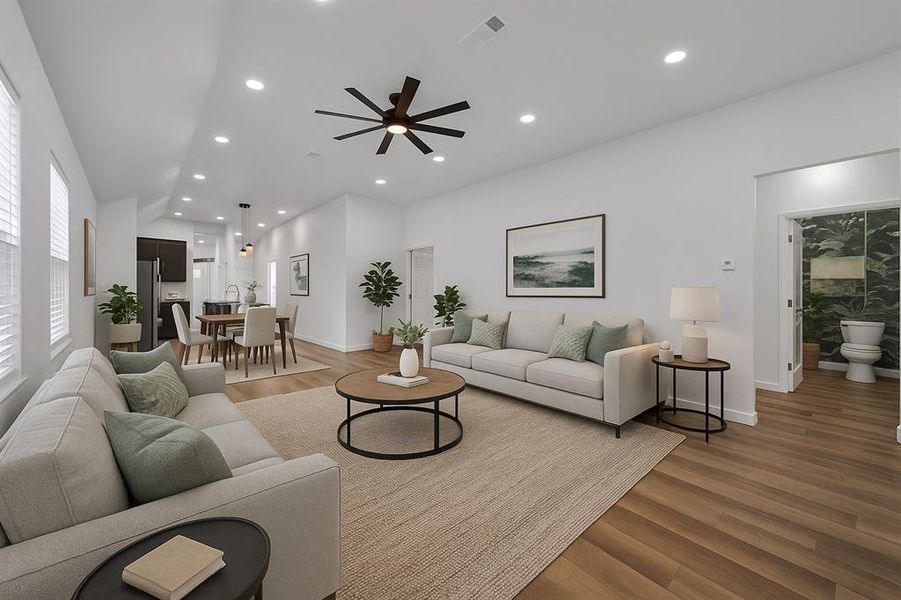 Staged - Living room featuring light wood-style floors, recessed lighting, ceiling fan, and vaulted ceiling