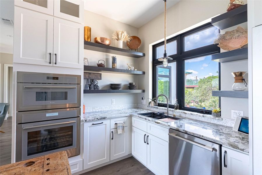 White cabinetry, open shelving, and sleek finishes create a modern vibe.