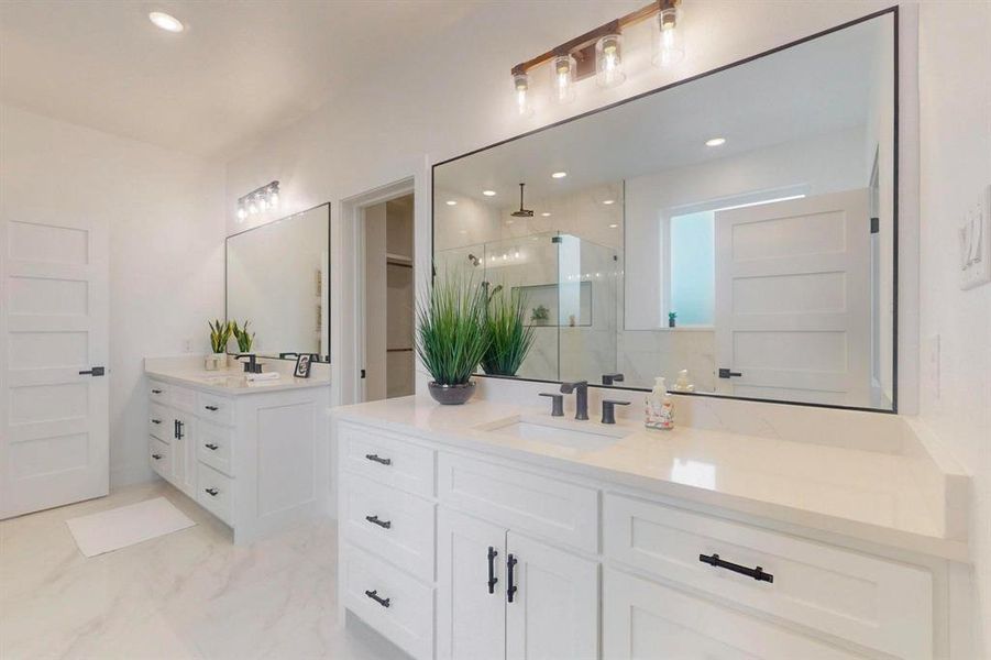 Full bathroom with recessed lighting, marble finish floor, a sink, a stall shower, and two vanities Full bathroom with recessed lighting, marble finish floor, a sink, a stall shower, and two vanities