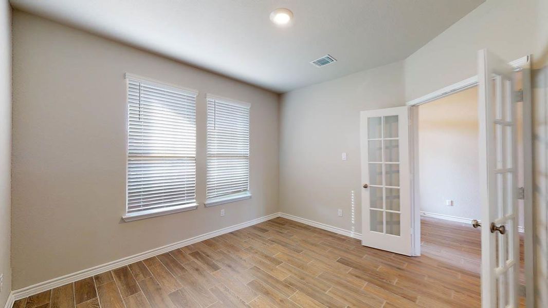 Empty room with french doors, wood tiled floors, and recessed lighting Empty room with french doors, wood tiled floors, and recessed lighting