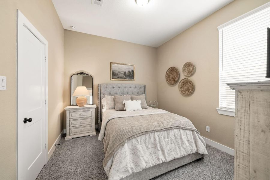 The third bedroom offers plush carpet and a window with blinds that brings in natural light while providing added privacy, creating a comfortable and inviting space for family or guests.