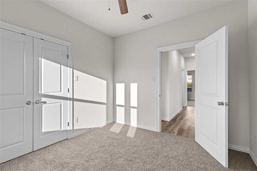 Unfurnished bedroom featuring carpet floors, a closet, and a ceiling fan