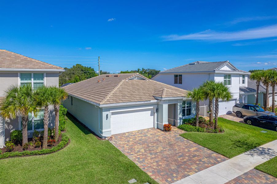 Front exterior of a new home in Windsong Estates, Lake Worth, FL, highlighting curb appeal (Image 25).