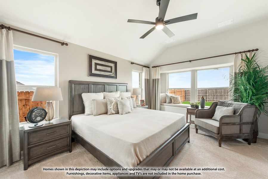 Master bedroom with vaulted ceiling, ceiling fan, dark wood furniture, and large windows with natural light.