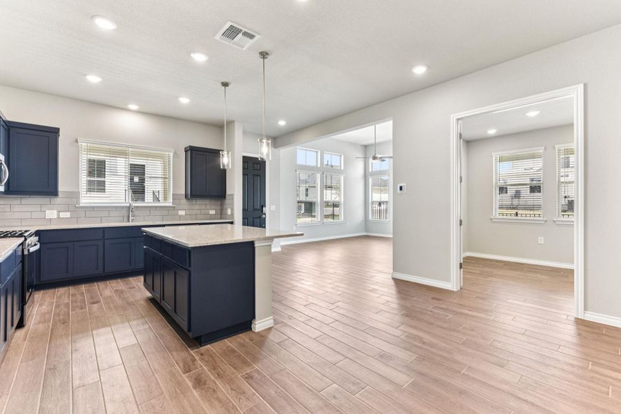 Kitchen featuring decorative backsplash, a center island, recessed lighting, open floor plan, and pendant lighting Kitchen featuring decorative backsplash, a center island, recessed lighting, open floor plan, and pendant lighting