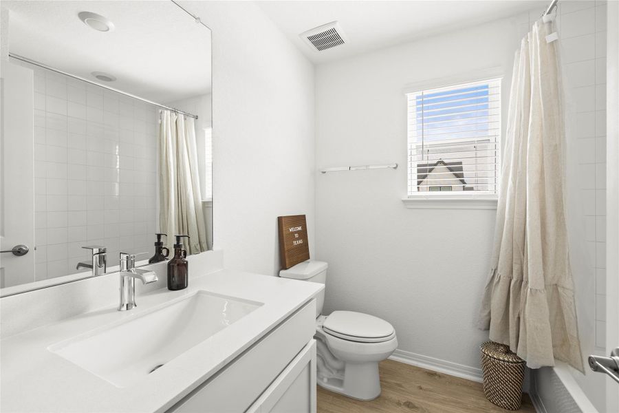 A well-lit bathroom with a bright window, offering a clean and modern aesthetic.