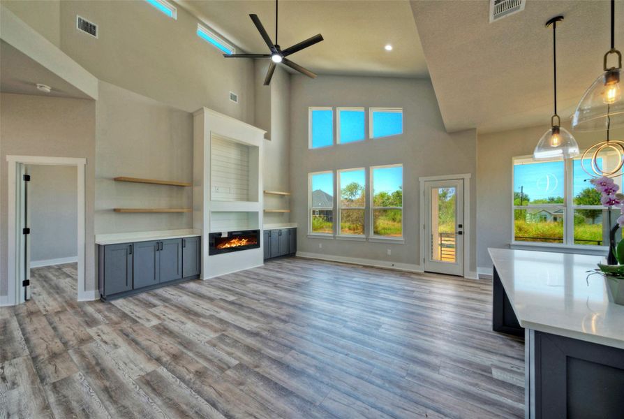 High vaulted ceilings and custom built-ins frame this open main living space with wood floors. High vaulted ceilings and custom built-ins frame this open main living space with wood floors.