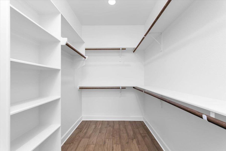 Walk in closet with dark wood-style floors Walk in closet with dark wood-style floors