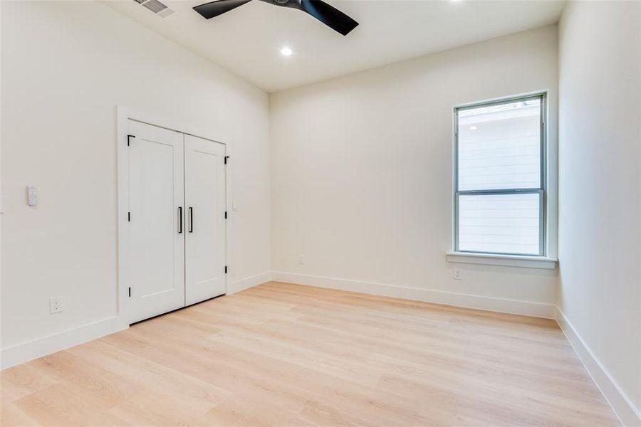 Unfurnished bedroom with light wood-type flooring, a closet, ceiling fan, and recessed lighting