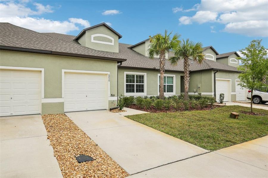 Front exterior of a new home in Abbott Square: The Villas, Zephyrhills, FL, highlighting curb appeal (Image 24). Front exterior of a new home in Abbott Square: The Villas, Zephyrhills, FL, highlighting curb appeal (Image 24).