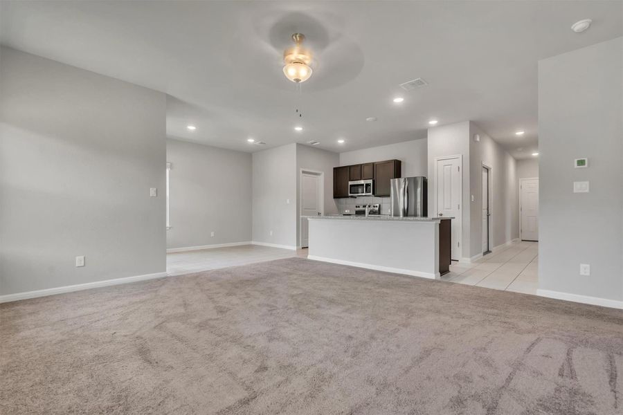 An open-concept living space transitions seamlessly into a well-appointed kitchen, ideal for entertaining.