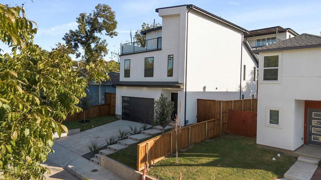 View of property exterior with a yard, a balcony, and a garage