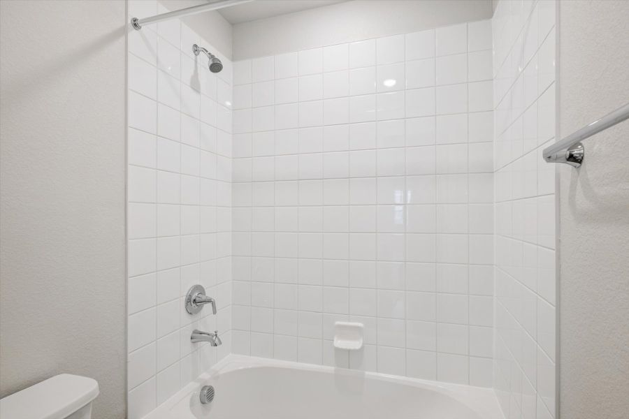 A white bathroom with a bathtub. A white bathroom with a bathtub.