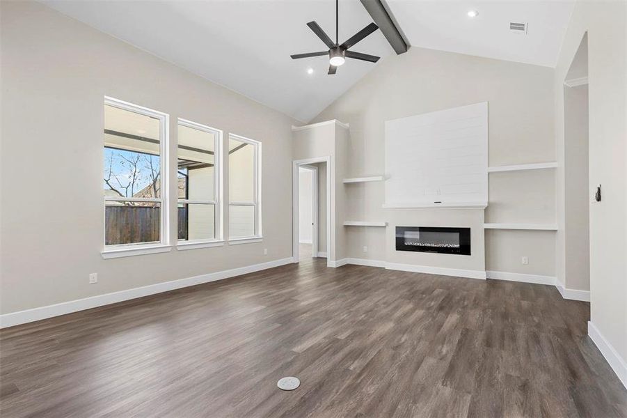 Unfurnished living room with ceiling fan, high vaulted ceiling, dark hardwood / wood-style flooring, and beam ceiling