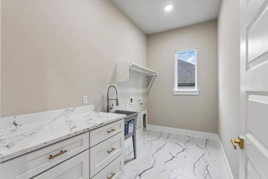 Functional utility room with ample countertop space, a practical sink, and organized shelving.