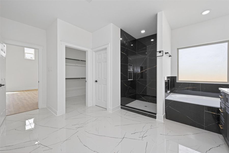 Spa-inspired primary bath with double-sink vanity, soaking tub, walk-in shower, and modern finishes.