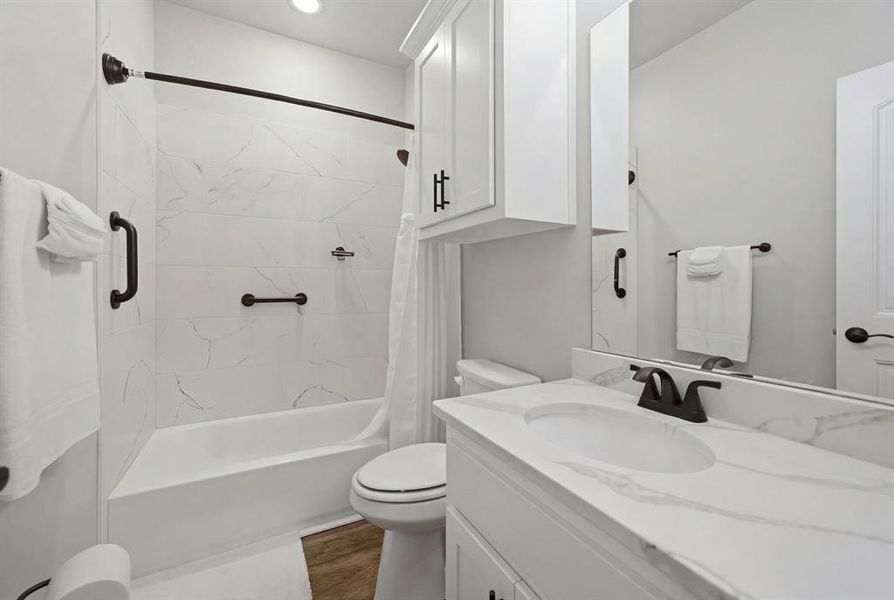 Full bathroom with vanity, shower / tub combo with curtain, and dark wood finished floors