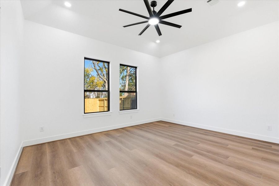 The primary suite, conveniently located on the first floor, showcases 11-foot ceilings, recessed lighting, and an exceptional en suite retreat.