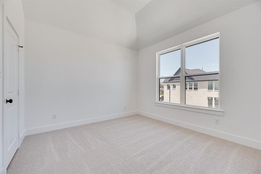 Empty room with light colored carpet and vaulted ceiling Empty room with light colored carpet and vaulted ceiling