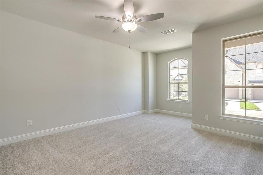 Empty room with light colored carpet and ceiling fan Empty room with light colored carpet and ceiling fan