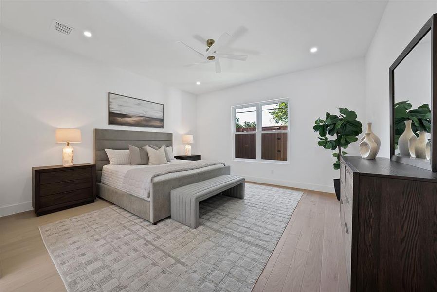 Bright interior space featuring a light wood-finish flooring, a contemporary ceiling fan, recessed lighting, white baseboards, and a large window