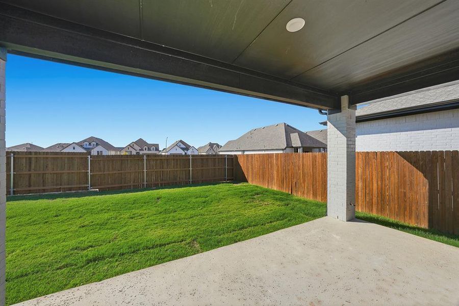 Fenced backyard featuring a patio area and a residential view Fenced backyard featuring a patio area and a residential view