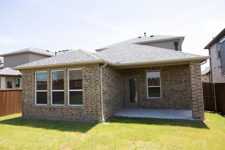 Rear view of house with brick siding, a patio area, and roof with shingles Rear view of house with brick siding, a patio area, and roof with shingles