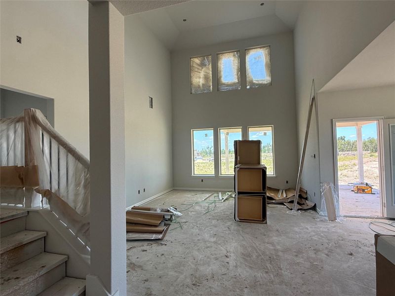 Living area featuring a high ceiling and stairs Living area featuring a high ceiling and stairs
