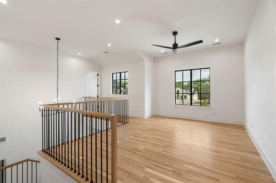 Upstairs Loft with light wood-style flooring, ceiling fan, and suspended lighting Upstairs Loft with light wood-style flooring, ceiling fan, and suspended lighting