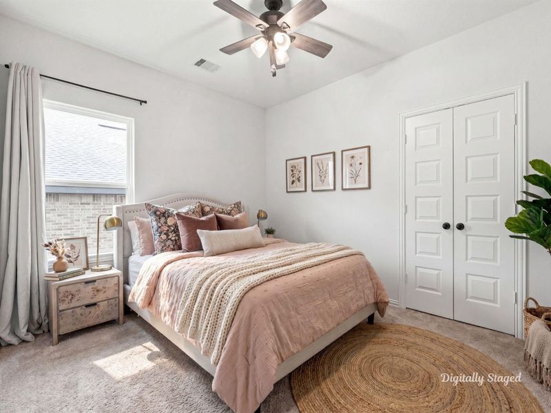 Comfortable secondary bedroom with soft carpet, a ceiling fan, and a sunny window. A double-door closet offers generous storage. This photo has been digitally staged to illustrate the possibilities of the home's aesthetic and potential design. Some furnishings and décor shown are for visual inspiration.
