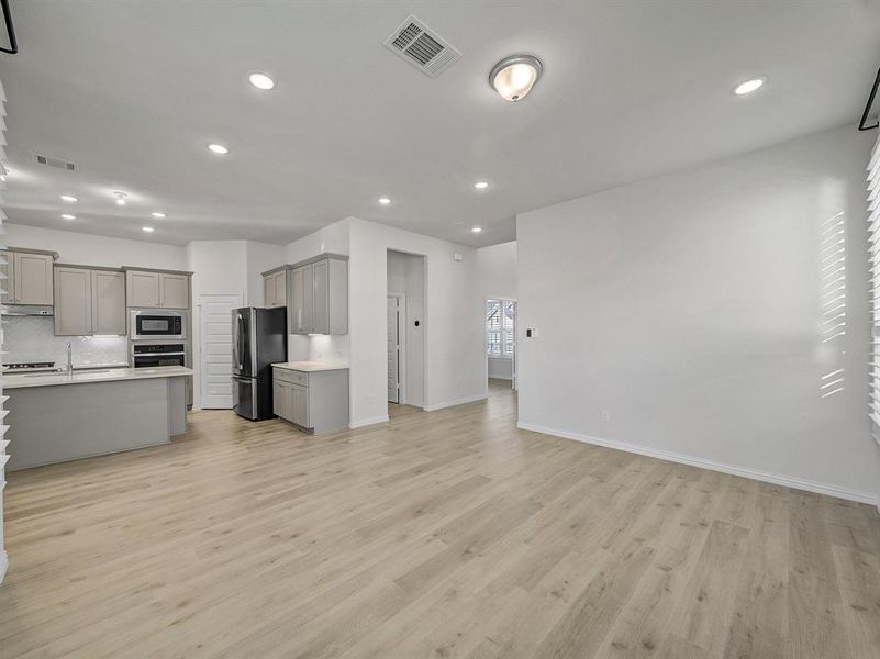 Kitchen featuring decorative backsplash, appliances with stainless steel finishes, gray cabinets, and light hardwood / wood-style flooring