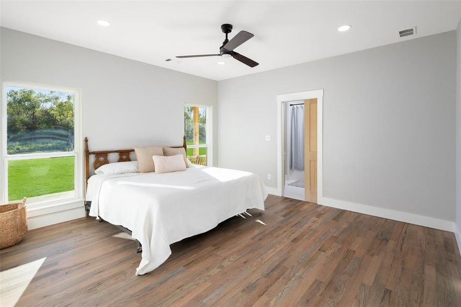 Bedroom featuring multiple windows, ceiling fan, and dark wood-type flooring