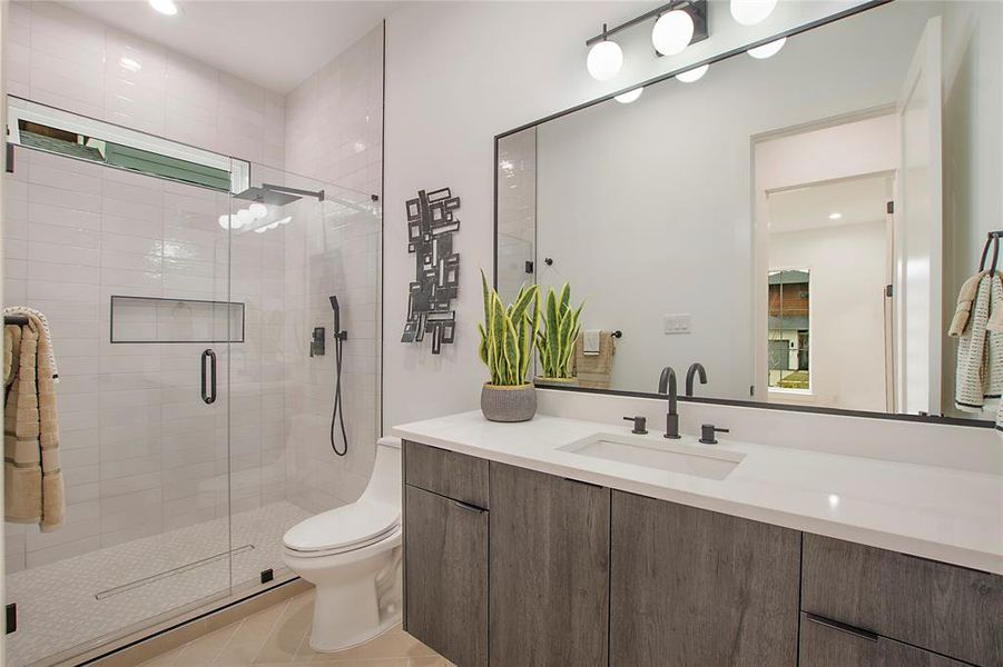 Bathroom with tile patterned flooring, vanity, toilet, and a shower with shower door