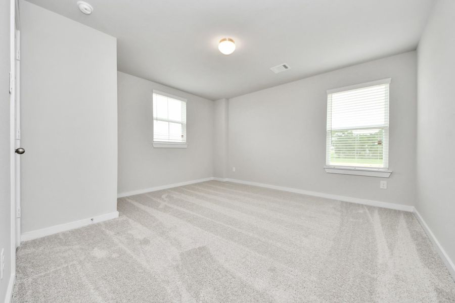 Secondary bedroom features plush carpeting, large windows that let in plenty of natural light, bright paint, and spacious closets. Sample photo of completed home with similar floor plan. Actual colors and selections may vary. Secondary bedroom features plush carpeting, large windows that let in plenty of natural light, bright paint, and spacious closets. Sample photo of completed home with similar floor plan. Actual colors and selections may vary.