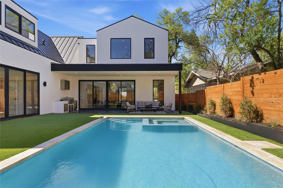An inviting backyard oasis awaits with a sparkling pool and a sophisticated outdoor lounge area. An inviting backyard oasis awaits with a sparkling pool and a sophisticated outdoor lounge area.
