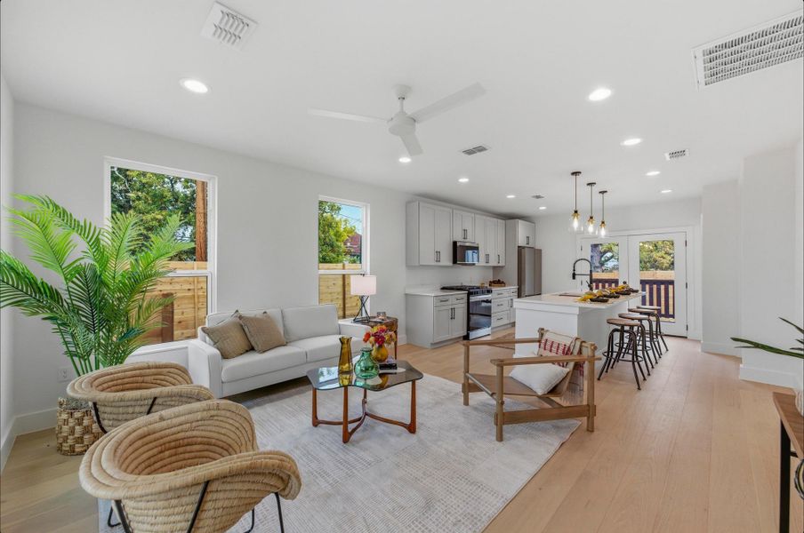Living area with recessed lighting, a ceiling fan, and light wood-type flooring