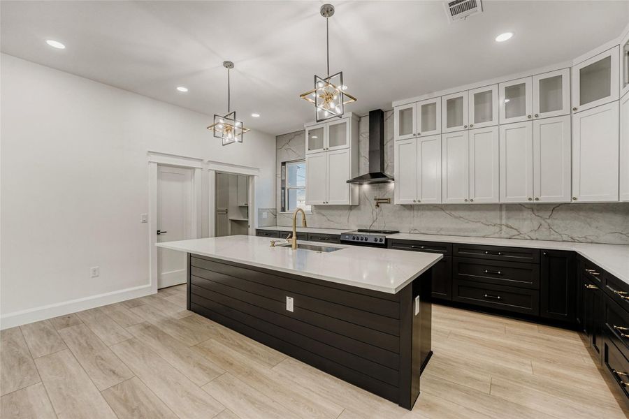 The modern kitchen of your dreams! Featuring custom contemporary cabinetry stretching to the ceiling with top level glass showcase cabinets.