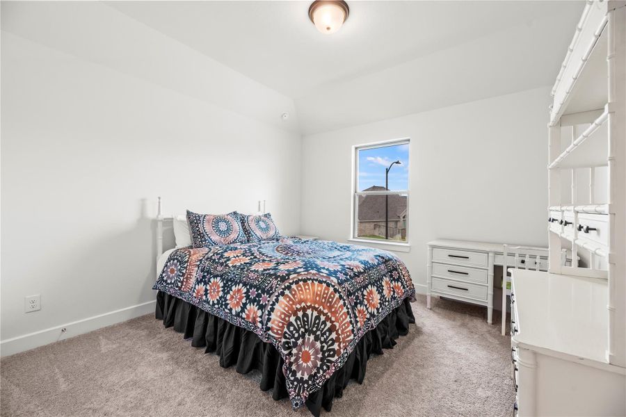 Another roomy guest room is ready to welcome family and visitors alike, featuring soft neutral paint, plush carpet, and a large closet for comfort and convenience.