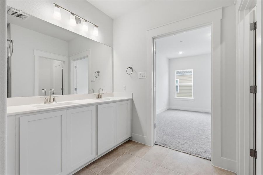 Bathroom featuring a dual vanity with a large mirror and overhead lighting