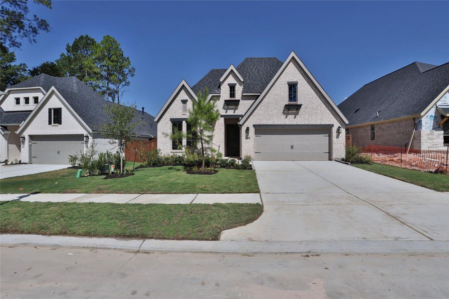 Front exterior of a new home in Woodhavyn, Magnolia, TX, highlighting curb appeal (Image 2). Front exterior of a new home in Woodhavyn, Magnolia, TX, highlighting curb appeal (Image 2).