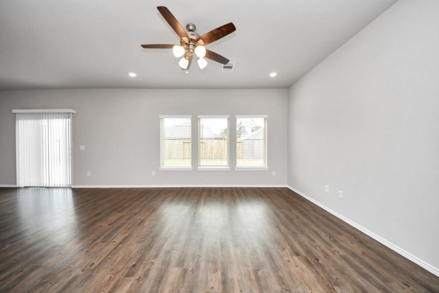 Spacious living room with vinyl floors throughout and blinds for privacy. Spacious living room with vinyl floors throughout and blinds for privacy.