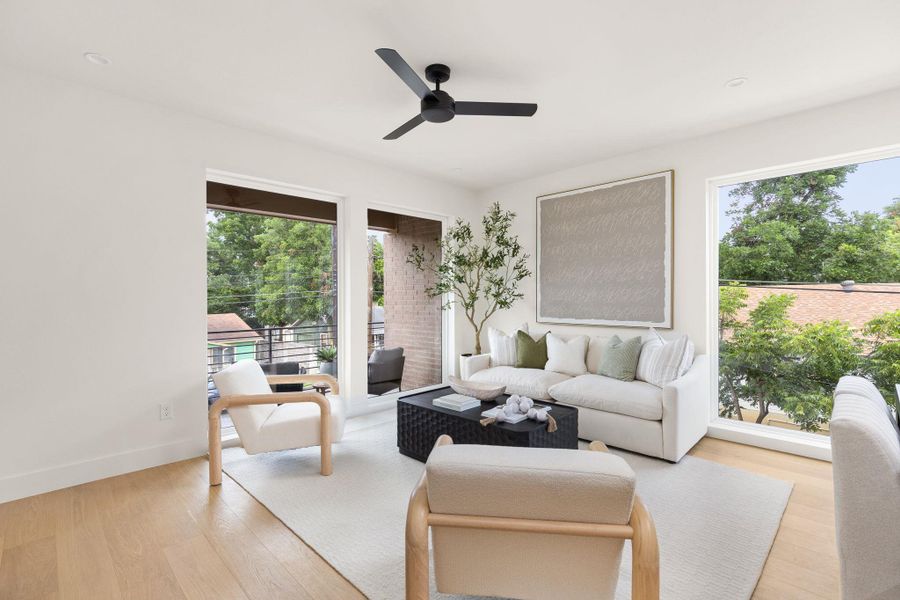 A naturally illuminated living room features sleek hardwood floors and ample light from expansive windows. A naturally illuminated living room features sleek hardwood floors and ample light from expansive windows.