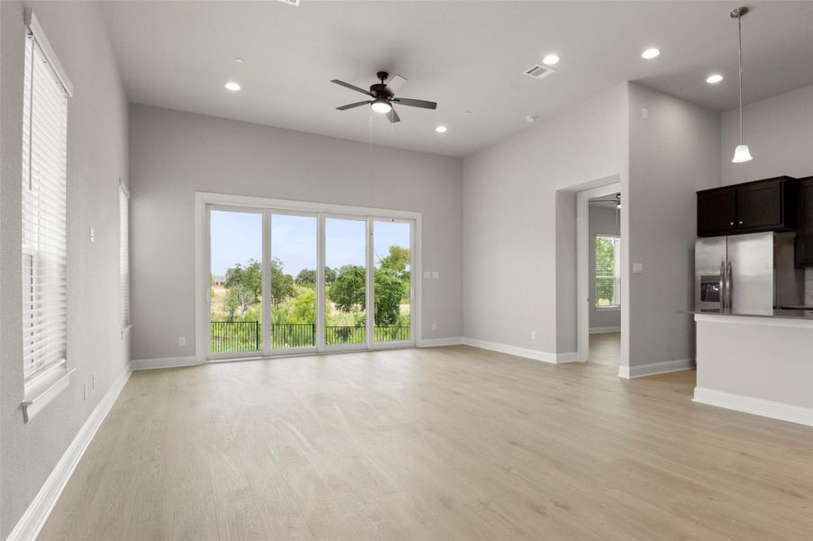 Unfurnished living room with light wood-style flooring, a ceiling fan, and recessed lighting