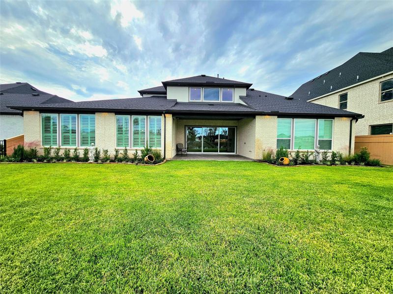 A spacious, modern home with large windows, a well-maintained lawn, and a covered patio area, perfect for outdoor relaxation and entertaining. A spacious, modern home with large windows, a well-maintained lawn, and a covered patio area, perfect for outdoor relaxation and entertaining.