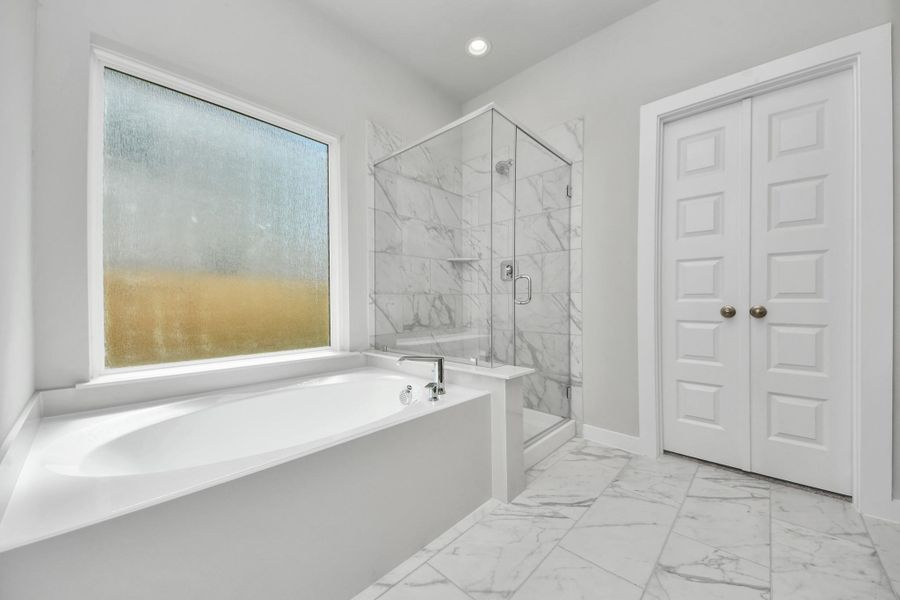 Indulge in a spa-like retreat within the confines of this primary bathroom. Delight in a spacious walk-in shower enveloped in stylish tile surround, unwind in a separate garden tub adorned with custom detailing. Sample photo of completed home with similar floor plan. Actual colors and selections may vary. Indulge in a spa-like retreat within the confines of this primary bathroom. Delight in a spacious walk-in shower enveloped in stylish tile surround, unwind in a separate garden tub adorned with custom detailing. Sample photo of completed home with similar floor plan. Actual colors and selections may vary.