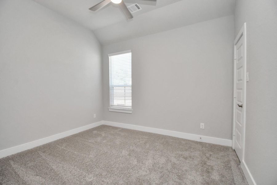 Secondary bedroom features plush carpeting, large windows that let in plenty of natural light, bright paint, and spacious closets. Sample photo of completed home with similar floor plan. Actual colors and selections may vary.