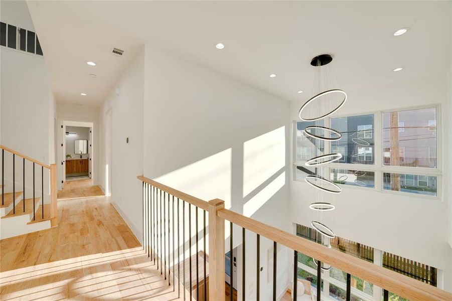 Hall with a notable chandelier and light hardwood / wood-style flooring